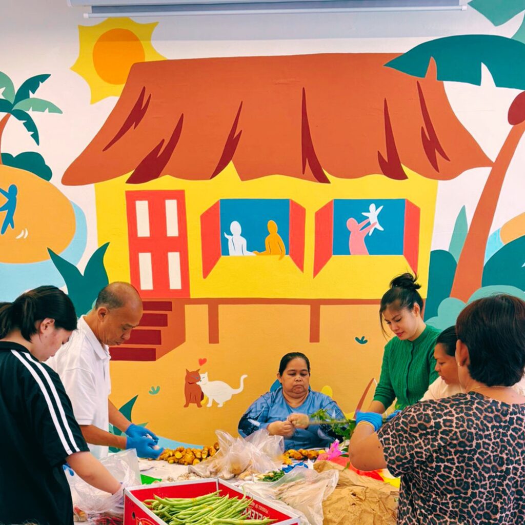 Community volunteers preparing food items for distribution through the Kasih Sayang Community Fridge initiative.